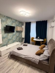 a bedroom with a large bed and a table at Happy Studio 1 in Craiova