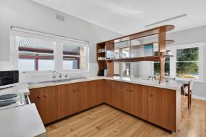 a kitchen with wooden cabinets and a large window at Hutchinson House in Goolwa