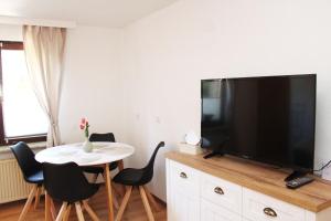 a living room with a table and a large flat screen tv at Ferienwohnung im Rauchwinkel in Hösseringen