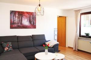 a living room with a couch and a painting on the wall at Ferienwohnung im Rauchwinkel in Hösseringen