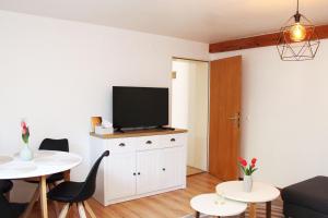 a living room with a flat screen tv on a white cabinet at Ferienwohnung im Rauchwinkel in Hösseringen
