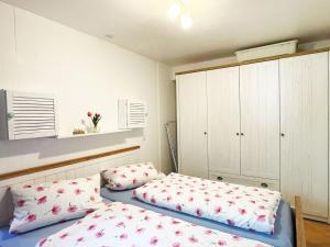 a bedroom with two beds and a cabinet at Ferienwohnung im Rauchwinkel in Hösseringen +13 photos