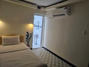 a bedroom with a bed and a door to a bathroom at Cozy rooms Asoke in Bangkok