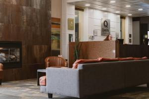 a woman standing behind a counter in a lobby at Quality Inn Rouyn-Noranda in Rouyn-Noranda