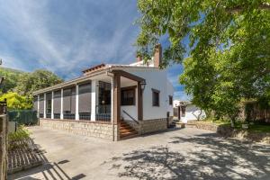 a white house with a fence in front of it at Casa Viria in Navaluenga