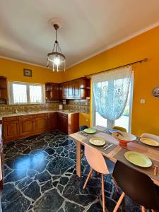 a kitchen with a table and chairs in a room at Errant Blue House Kyllini in Kyllini