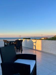 a patio with chairs and a table on a wall at Errant Blue House Kyllini in Kyllini +7 photos