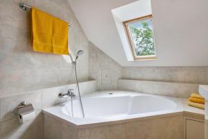 a white bath tub in a bathroom with a window at Sonnengelb - Fulgenhaus in Klein Bollhagen