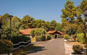 a street in front of a house with trees at Comfortable chalet in a vacation village in Gujan-Mestras