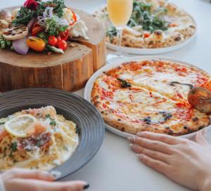 a table topped with plates of food and pizza at 森の宿 l ACAO FOREST 01 in Atami +18 photos