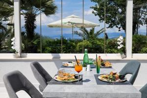 a table with plates of food and an umbrella at Blue Waves Resort in Malinska +117 photos