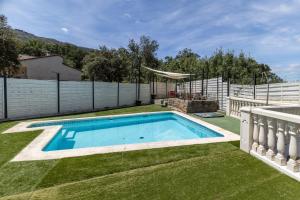 a swimming pool in the yard of a house at Casa Viria in Navaluenga