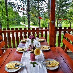 a wooden table with plates of food and flowers on it at Vikendica Ubla in Trebinje
