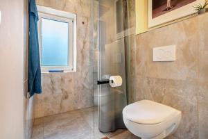 a bathroom with a toilet and a glass shower at Küstenblau - Fulgenhaus in Klein Bollhagen +12 photos