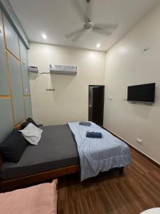 a bedroom with a bed and a flat screen tv at Golden Waves Guest House in Mahabalipuram +8 photos