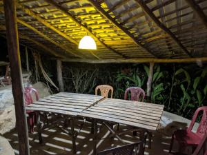 a wooden table and chairs on a patio at Achinthya Nature Resort in Avissawella
