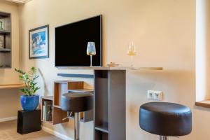 a bar with two stools in a room with a tv at Küstenblau - Fulgenhaus in Klein Bollhagen