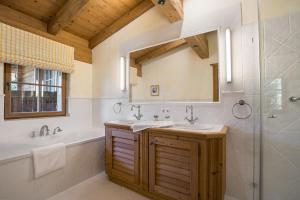 a bathroom with a tub and a sink and a mirror at Chalet Lebenberg Kitzbühel in Kitzbühel +35 photos