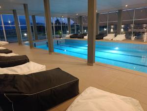 a swimming pool with couches in a building at Europa Hotel Korinos in Korinos