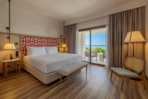 a hotel room with a bed and a balcony at Sarena de Muro Resort Mallorca, part of Destination by Hyatt in Playa de Muro