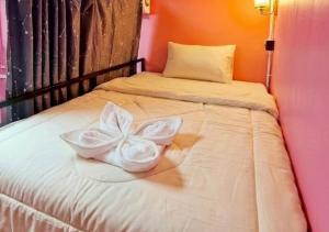 a pair of white wedding shoes sitting on a bed at DISCO ZOO Bar & Hostel in Haad Rin