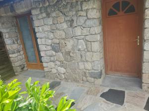 an entrance to a stone building with a wooden door at Tranquillité in Le Cheylard +1 photo