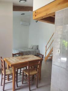 a dining room with a table and chairs and a bed at Tranquillité in Le Cheylard