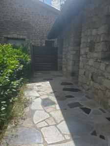 a stone walkway leading to a building with a gate at Tranquillité in Le Cheylard