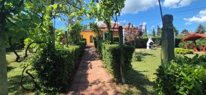 a garden path leading to a yellow house at Bazsarózsa Apartmanok Csopak in Csopak