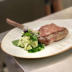 a plate with a piece of meat and a salad at Adler Oberdorf in Langenargen +35 photos