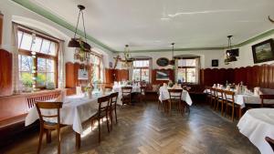 a restaurant with white tables and chairs and windows at Adler Oberdorf in Langenargen