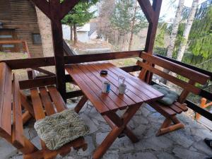 a wooden picnic table and a bench on a patio at Sova Kopaonik in Kopaonik