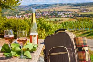 a table with two glasses of wine and a backpack at Flair Hotel Weinstube Lochner in Bad Mergentheim