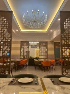 a restaurant with tables and chairs and a chandelier at The Leith in George Town