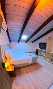 a bedroom with a large bed and a wooden ceiling at Oborri Shkodran Boutique Hotel in Shkodër