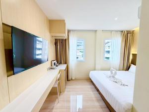a hotel room with two beds and a flat screen tv at Le Hong Hotel Pratunam in Bangkok