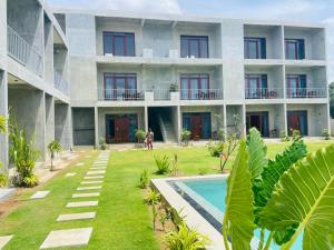 an apartment building with a courtyard and a swimming pool at Doppel Gangs Arugambay in Arugam Bay