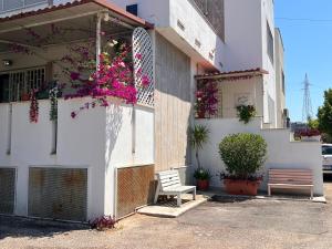 a white building with a bench and flowers on it at Villa COME A CASA TUA in Bari