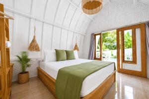 a bedroom with a bed and a window at Kelapa Lodge - Lombok - in Senggigi