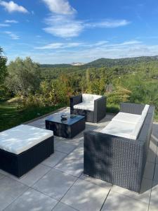 a patio with three chairs and a table and a view at La Maison Bernard in Roquefort-la-Bédoule