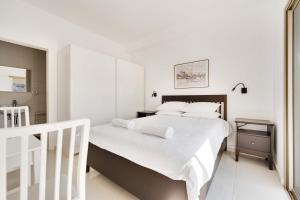 a white bedroom with a large bed with white sheets at Spacious Sea-View Penthouse + Big Balconies in Ashdod +33 photos