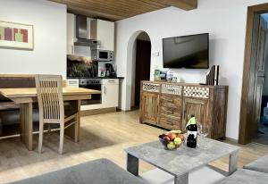 a kitchen and living room with a table and a television at Haus Hofer in Bramberg am Wildkogel +33 photos