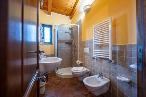 a bathroom with two sinks and a toilet and a shower at B&B Casale Pietrantica Tropea in Ciaramiti