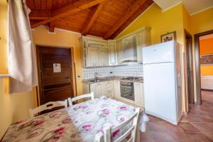 a kitchen with a table and a white refrigerator at B&B Casale Pietrantica Tropea in Ciaramiti +212 photos