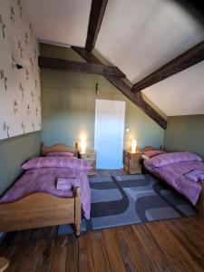 two beds in a room with wooden floors at Thunder Roadhouse in La Mothe-Saint-Héray