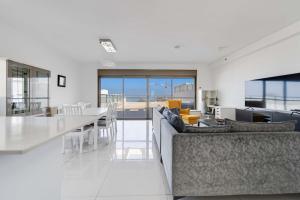 a living room with a couch and a table at Spacious Sea-View Penthouse + Big Balconies in Ashdod
