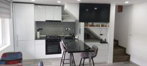 a kitchen with white cabinets and a black counter top at Casa ALBERT in Brezoi