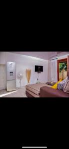 a living room with a bed and a television at ShanazNest in Bulawayo
