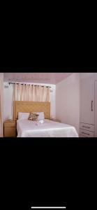 a bedroom with a large bed with a white bedspread at ShanazNest in Bulawayo