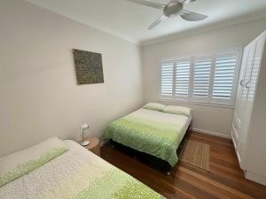 a bedroom with two beds and a ceiling fan at Three Fifty Four Straight St Hat Head - Bring your own linen. in Hat Head